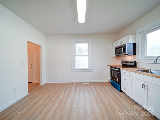 55 Ranlo Ave, Gastonia, NC 28054 - kitchen featuring a sink, electric range oven, plenty of natural light, light wood-style flooring, and stainless steel microwave