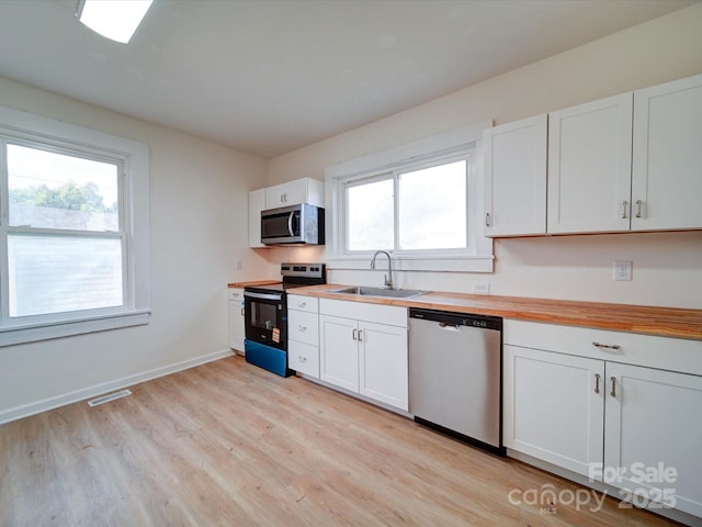 55 Ranlo Ave, Gastonia, NC 28054 - kitchen featuring stainless steel appliances, wood counters, a sink, and light wood-type flooring