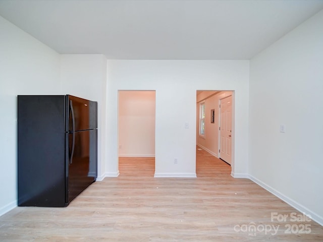 55 Ranlo Ave, Gastonia, NC 28054 - unfurnished bedroom featuring baseboards, freestanding refrigerator, and light wood-style flooring