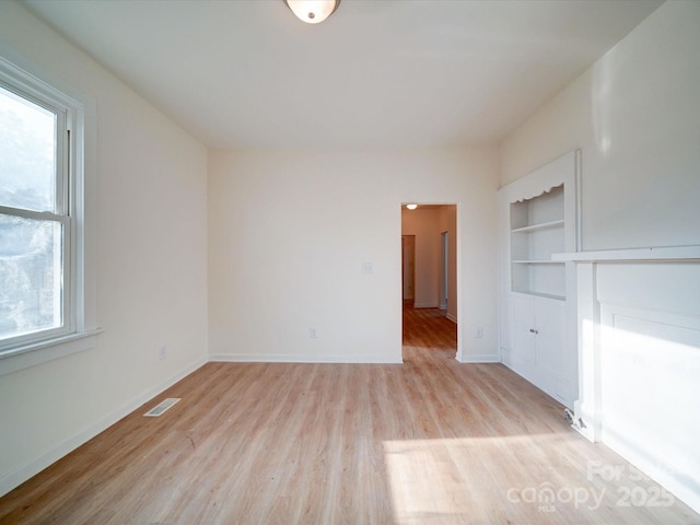 55 Ranlo Ave, Gastonia, NC 28054 - unfurnished living room with built in features, baseboards, light wood-style flooring, and visible vents