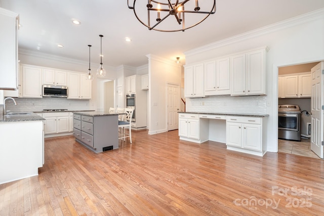 kitchen with a center island, decorative backsplash, stainless steel appliances, and white cabinetry
