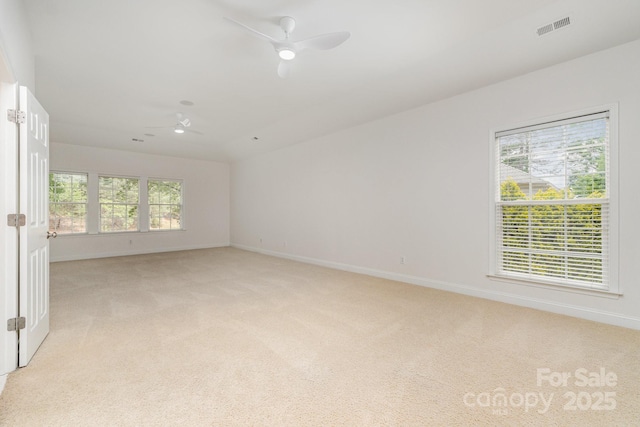 spare room featuring visible vents, a ceiling fan, baseboards, and light colored carpet