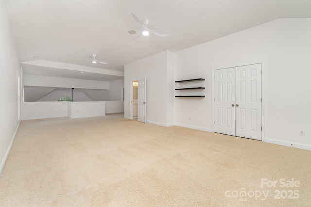 interior space featuring ceiling fan, baseboards, and lofted ceiling