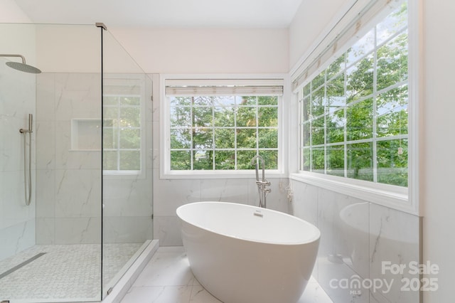 full bath featuring plenty of natural light, a marble finish shower, and a freestanding bath