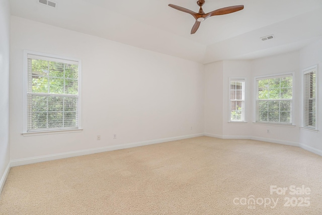 empty room featuring visible vents, baseboards, ceiling fan, and light carpet