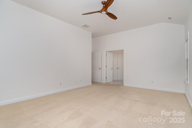spare room with visible vents, light carpet, baseboards, a ceiling fan, and vaulted ceiling