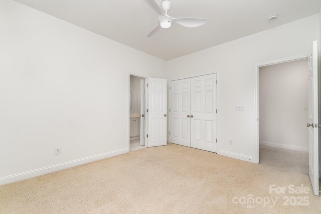 unfurnished bedroom featuring ceiling fan, baseboards, a closet, ensuite bathroom, and carpet flooring