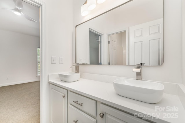 bathroom with double vanity, baseboards, and a sink