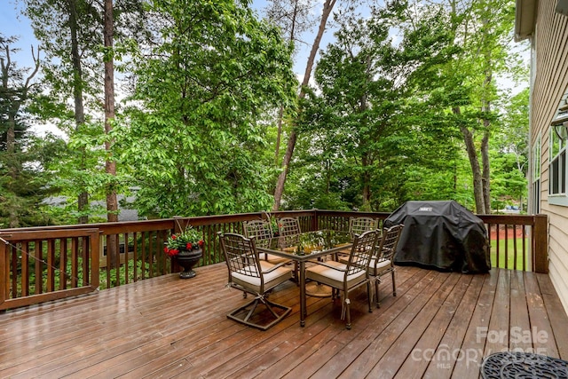 wooden terrace featuring outdoor dining space and area for grilling