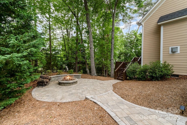 view of patio / terrace featuring an outdoor fire pit, a wooden deck, and stairway