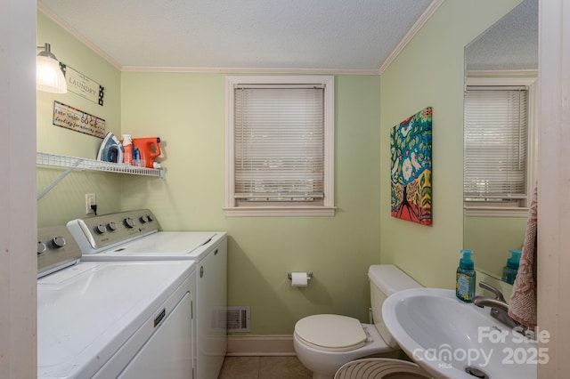 bathroom with washer and dryer, a sink, toilet, a textured ceiling, and crown molding