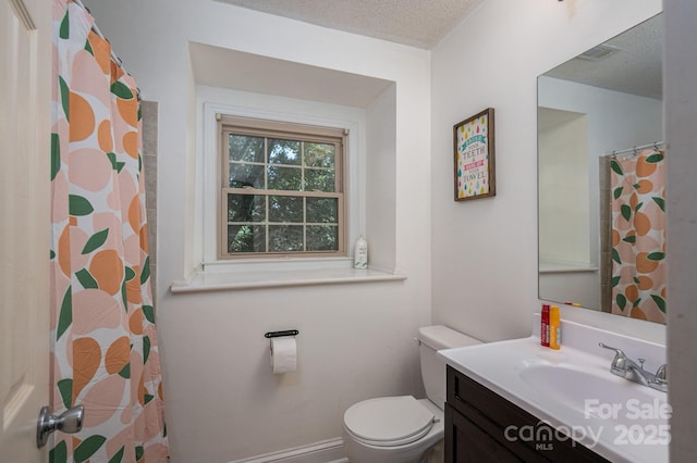 bathroom with toilet, vanity, and a textured ceiling