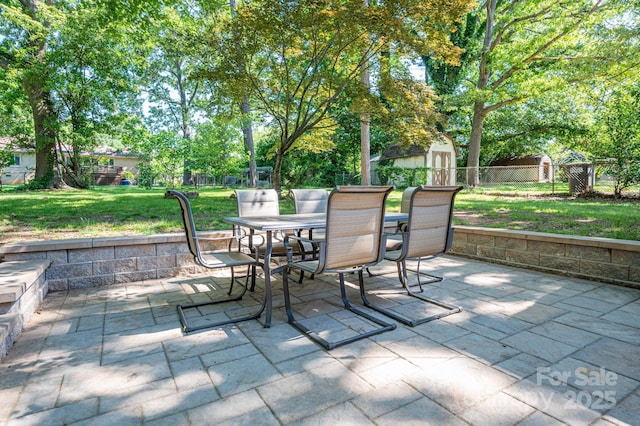 view of patio / terrace with outdoor dining space, a storage shed, and an outdoor structure