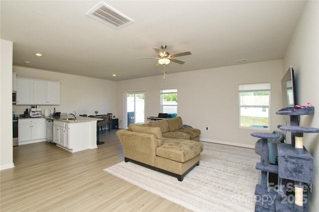 living room featuring ceiling fan, recessed lighting, baseboards, light wood-type flooring, and visible vents