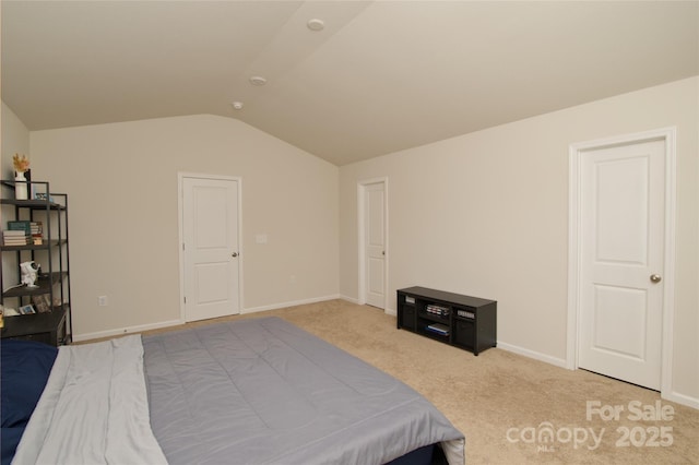 bedroom with baseboards, light colored carpet, and lofted ceiling