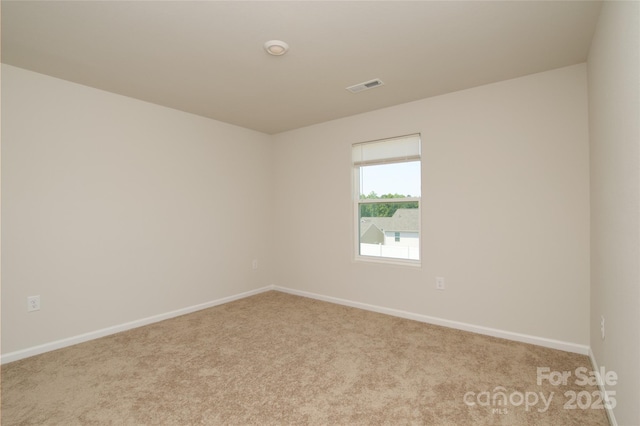 carpeted empty room featuring baseboards and visible vents