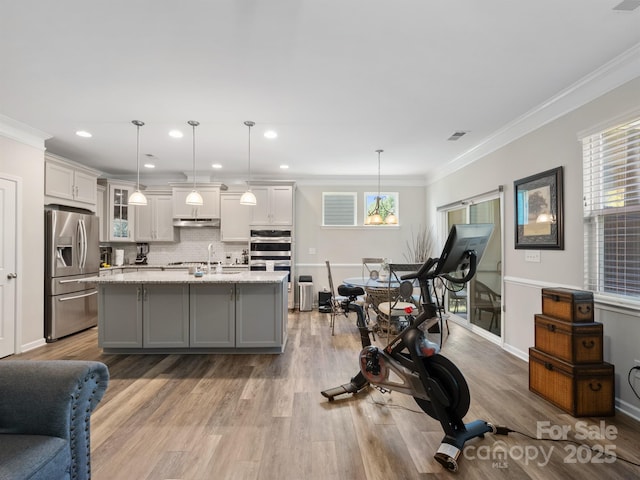4316 Falls Lake Dr SW, Concord, NC 28025 - kitchen featuring stainless steel appliances, under cabinet range hood, glass insert cabinets, decorative backsplash, and ornamental molding