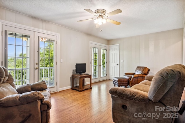 2196 Uphill Ln, Lenoir, NC 28645 - living area featuring light wood-style flooring, ceiling fan, french doors, a textured ceiling, and baseboards