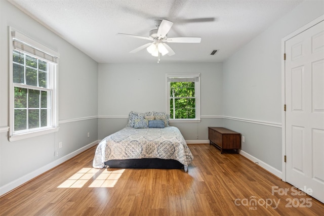 2196 Uphill Ln, Lenoir, NC 28645 - bedroom featuring multiple windows, wood finished floors, baseboards, and a ceiling fan