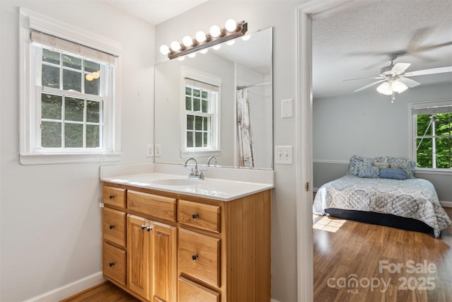 2196 Uphill Ln, Lenoir, NC 28645 - full bath featuring wood finished floors, a ceiling fan, vanity, connected bathroom, and baseboards