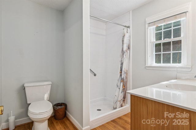 2196 Uphill Ln, Lenoir, NC 28645 - bathroom featuring wood finished floors, a stall shower, toilet, a sink, and baseboards