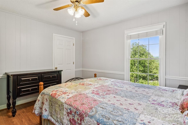 2196 Uphill Ln, Lenoir, NC 28645 - bedroom featuring wood finished floors, a ceiling fan, a decorative wall, and ornamental molding
