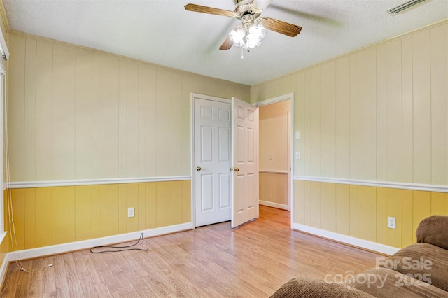 2196 Uphill Ln, Lenoir, NC 28645 - unfurnished room with wood finished floors, baseboards, a ceiling fan, and wooden walls