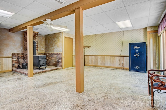 2196 Uphill Ln, Lenoir, NC 28645 - below grade area featuring a paneled ceiling, a wood stove, wallpapered walls, a wainscoted wall, and carpet