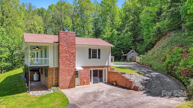 2196 Uphill Ln, Lenoir, NC 28645 - view of front facade with asphalt driveway, a chimney, a front yard, brick siding, and a patio