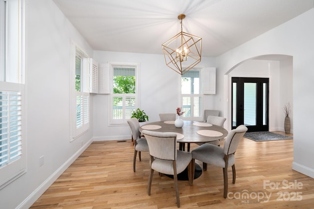 44 White Thorn Dr, Alexander, NC 28701 - dining space featuring an inviting chandelier, baseboards, light wood finished floors, and arched walkways