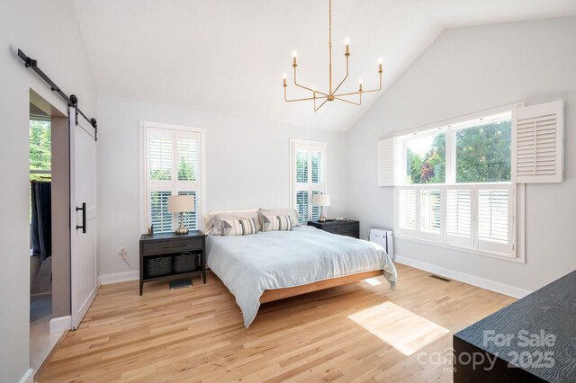 44 White Thorn Dr, Alexander, NC 28701 - bedroom with a notable chandelier, a barn door, multiple windows, and light wood-style floors