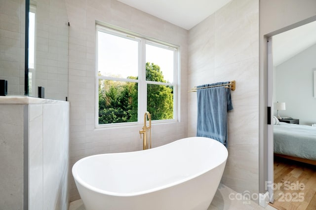 44 White Thorn Dr, Alexander, NC 28701 - bathroom featuring connected bathroom, a freestanding tub, tile walls, and wood finished floors