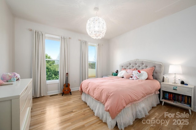 44 White Thorn Dr, Alexander, NC 28701 - bedroom with baseboards, an inviting chandelier, visible vents, and light wood-type flooring