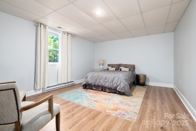 44 White Thorn Dr, Alexander, NC 28701 - bedroom featuring baseboards, a baseboard radiator, a paneled ceiling, and wood finished floors