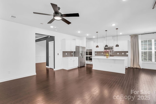 unfurnished living room with ceiling fan, dark wood finished floors, recessed lighting, baseboards, and visible vents