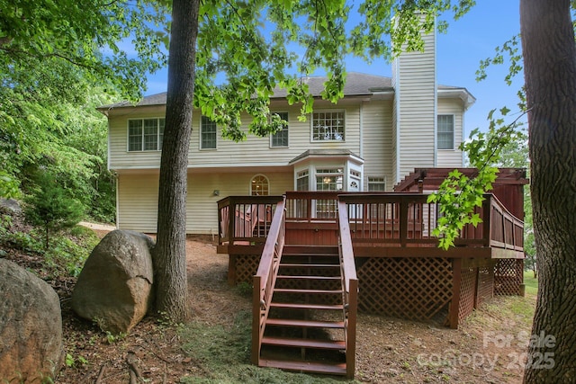 back of house featuring a deck, a chimney, and stairway
