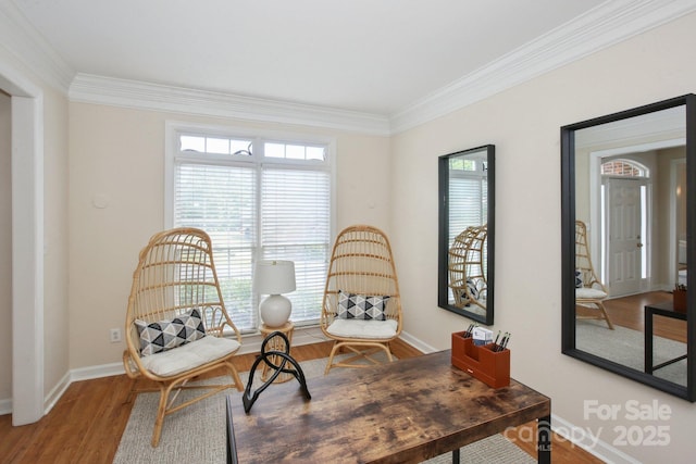 living area with crown molding, baseboards, and wood finished floors