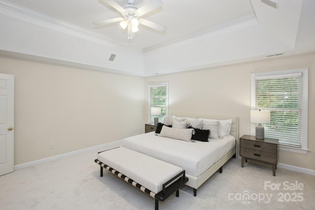 bedroom with crown molding, a tray ceiling, and light colored carpet