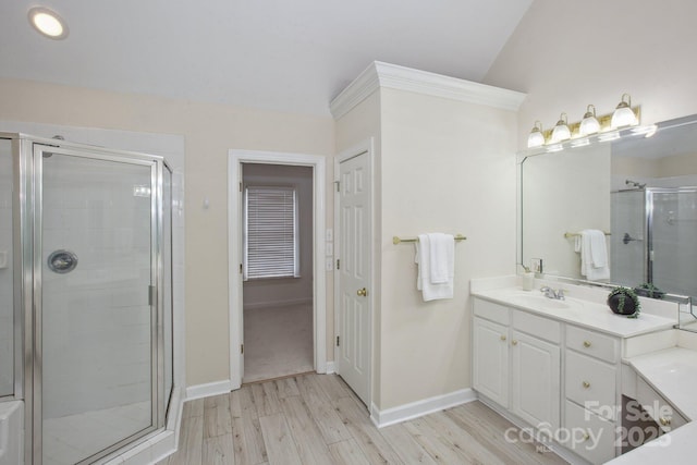full bathroom with vanity, baseboards, a stall shower, and wood finished floors