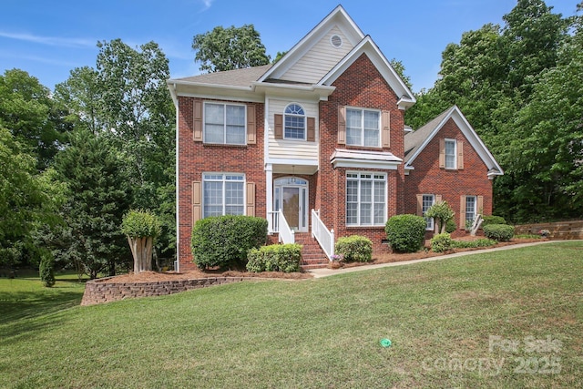 colonial home with brick siding and a front yard