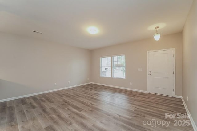 unfurnished room with wood finished floors and baseboards