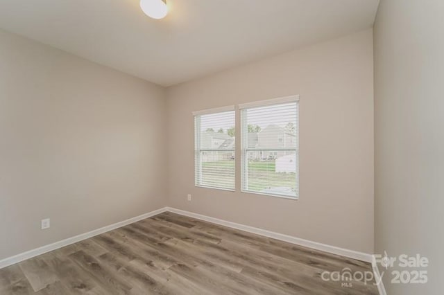 unfurnished room with wood finished floors and baseboards