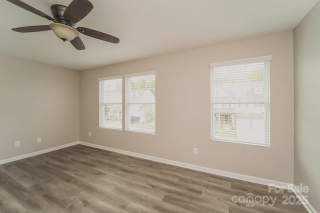unfurnished room featuring ceiling fan, baseboards, and dark wood-style floors