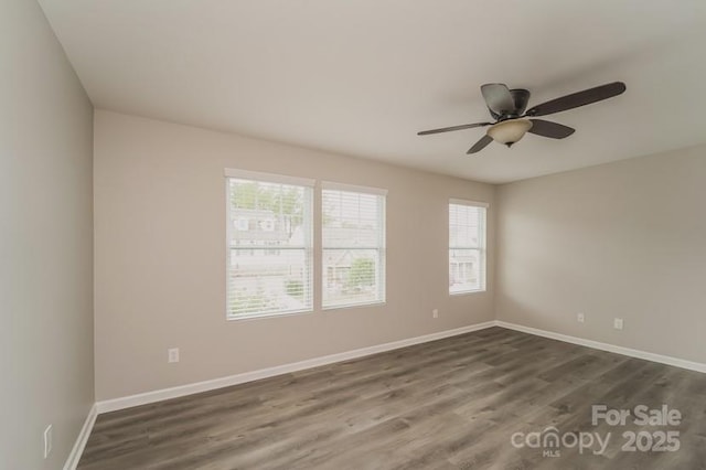 unfurnished room featuring dark wood-style flooring, baseboards, and ceiling fan