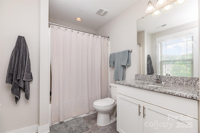 bathroom with toilet, vanity, and tile patterned floors