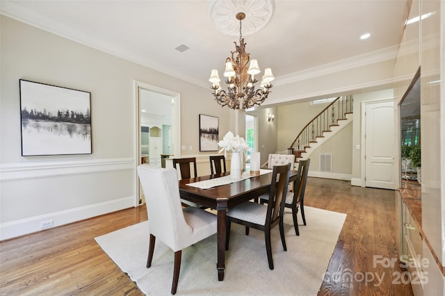 5701 Challisford Ln, Charlotte, NC 28226 - dining space with visible vents, ornamental molding, wood finished floors, stairway, and a chandelier
