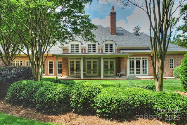 5701 Challisford Ln, Charlotte, NC 28226 - back of property with roof with shingles, french doors, brick siding, a chimney, and a lawn