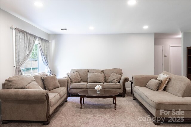 living room with visible vents, recessed lighting, and light colored carpet