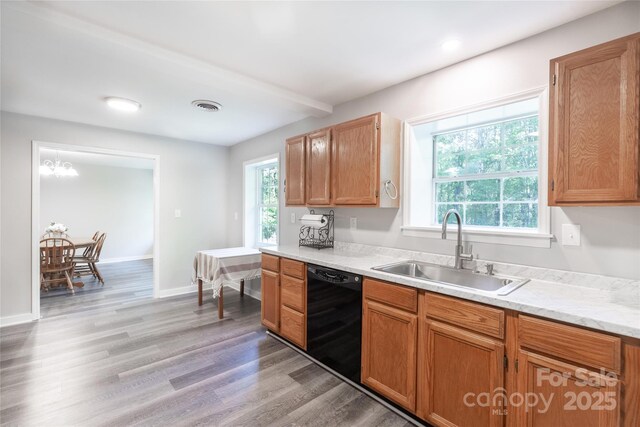 kitchen featuring visible vents, light countertops, a sink, light wood-style flooring, and dishwasher