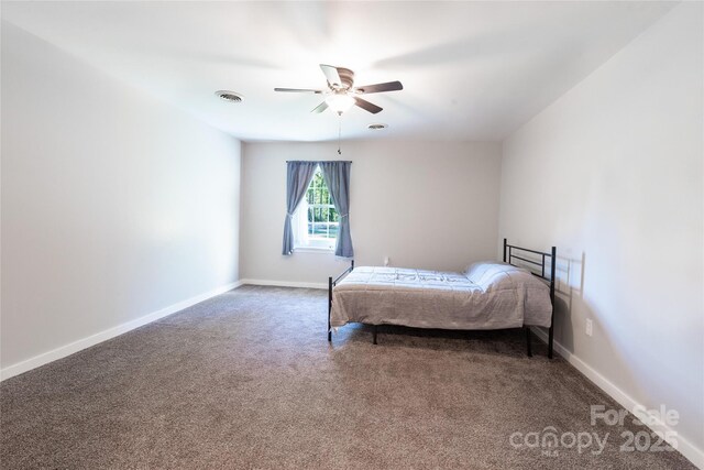 carpeted bedroom with baseboards, a ceiling fan, and visible vents